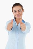 Smiling businesswoman giving both thumbs up