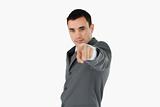 Side view of young businessman pointing towards camera