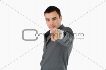 Side view of young businessman pointing towards camera