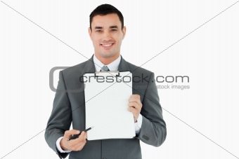 Businessman pointing with pen on clipboard