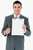 Smiling businessman pointing with pen at clipboard