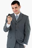 Smiling businessman looking at his cellphone