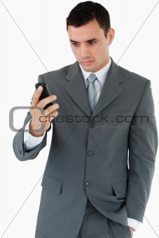 Serious looking businessman looking at his cellphone