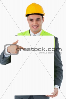 Smiling architect pointing on sign in his hands
