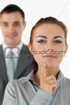 Close up of thinking businesswoman with colleague in the background