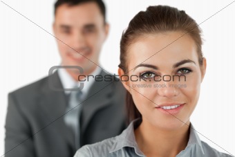 Close up of smiling businesswoman with colleague behind her