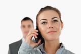 Close up of confident businesswoman on the phone with colleague behind her