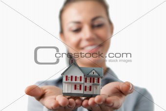 Close up of miniature house being held by female estate agent