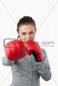 Businesswoman with boxing gloves slamming