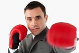 Close up of businessman with boxing gloves slamming