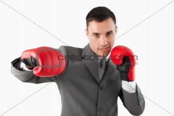 Close up of businessman with boxing gloves striking a hook