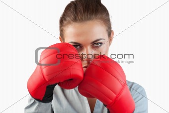 Close up of serious businesswoman with boxing gloves