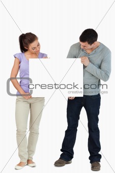 Young couple looking at sign they are holding