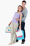 Young male holding his girlfriend with her shopping