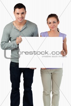 Young couple holding banner together