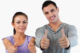 Young couple giving thumbs up