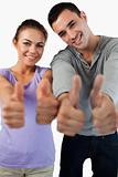 Close up of young couple giving thumbs up