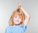 boy with long blond hair pointing up - isolated on gray