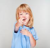boy with long blond hair pointing towards the camera - focus on finger