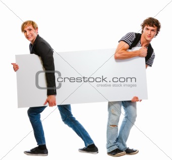 Two teenagers pulling blank billboard. Isolated on white
