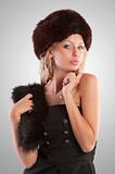 blond girl with fur hat on spotlight background