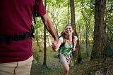 young couple trekking in forest and holding hands