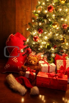 Brightly lit Christmas tree with gifts