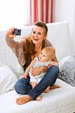 Beautiful young mom making photos with her lovely baby