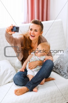 Beautiful young mom making photos with her lovely baby
