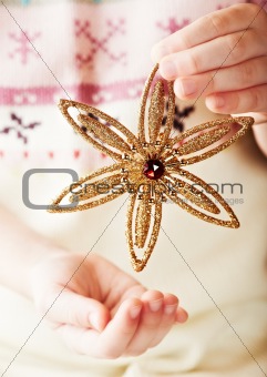 Child's hands holding golden christmas star