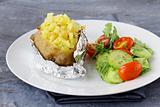 Baked potato filled with sour cream and  cheese, with salad