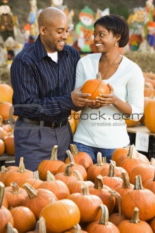 Couple buying pumpkin.