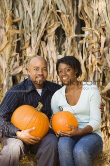 Couple holding pumpkins.