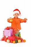 Boy in santa hat with christmas baubles and presents - isolated 