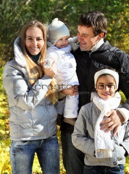 Young happy family in autumn forest