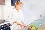 woman making morning juice in kitchen