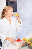 woman drinking fresh juice in kitchen