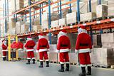 santa clauses in the line for the sacks of gifts in storehouse
