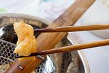 Bamboo chopsticks holding deep-fried dough stick