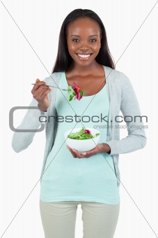 Young woman eating salad