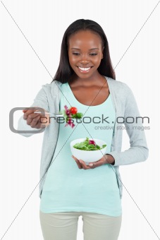 Young woman with salad on her fork