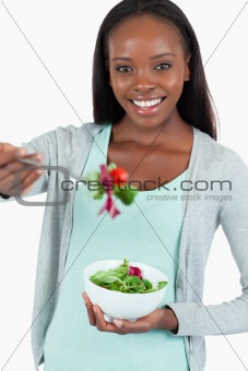Happy smiling woman offering some salad