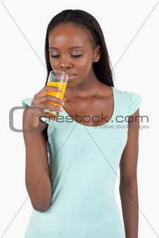 Young woman looking into her glass of orange juice