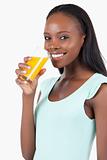 Side view of smiling woman with orange juice