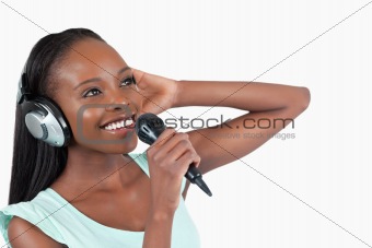 Smiling woman with headphones on singing