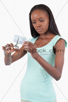 Sad looking female destroying her credit card