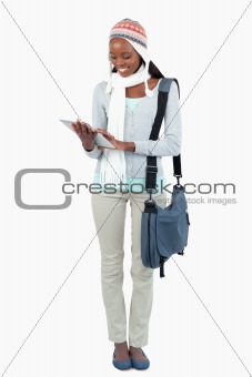 Smiling young woman with touchpad, scarf and hat