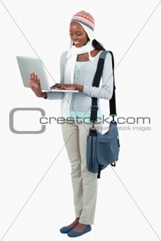 Side view of female student with laptop and winter clothing