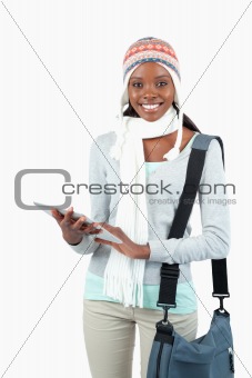 Smiling young student in winter clothes with her tablet