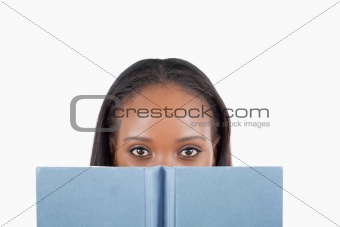 Young woman behind book